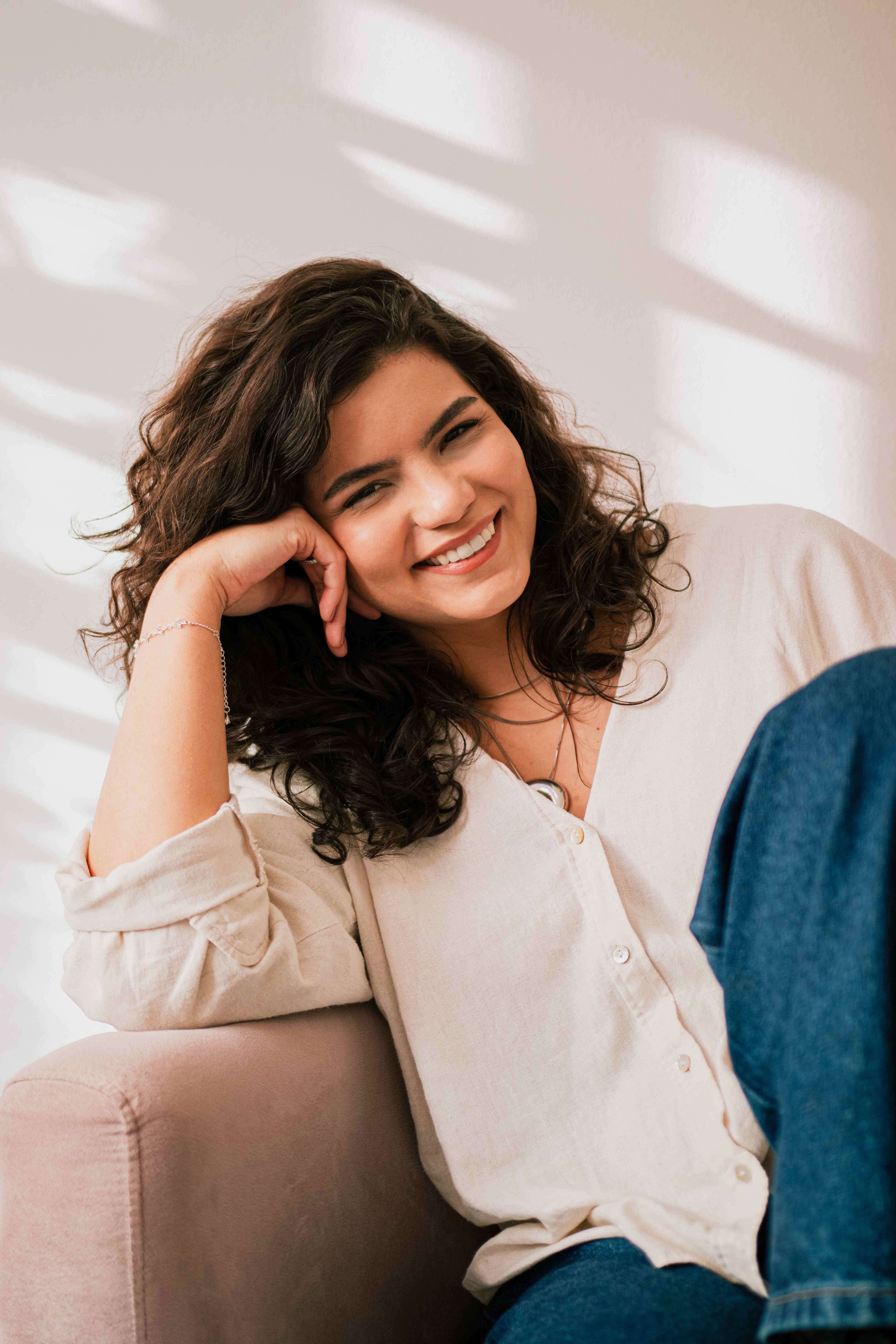 Caroline Leonel, psicóloga, sorrindo em ambiente iluminado